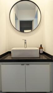 La salle de bains est pourvue d'un lavabo blanc et d'un miroir. dans l'établissement Departamento luminoso a estrenar con balcón, à Rosario