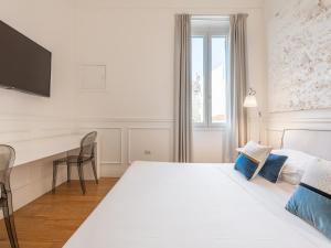 a hotel room with a bed and a desk at PLEY Boutique Del Centro in Cagliari