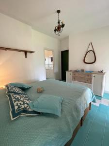 a bedroom with a large bed with blue pillows at Villa ValePina in Villasimius