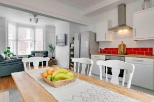 uma cozinha com uma mesa e uma cesta de frutas em Orange Rentals - In my 4 bedroom Liverpool Home em Liverpool