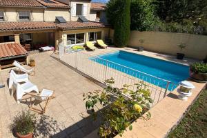 basen z dwoma krzesłami i dom w obiekcie Maison de famille (piscine, jacuzzi et sauna) w mieście Quillan