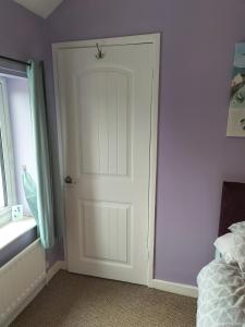 a white door in a bedroom with a window at Private room in Wrexham