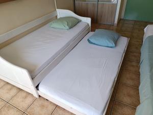 1 cama blanca con 2 almohadas en el suelo en Grand studio lumineux à Saint-Gilles-les-Bains, en Saint-Gilles-les-Bains