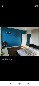 Habitación con pared azul y 2 camas en Charmant T2 refait à neuf, au cœur de Puylaurens en Puylaurens