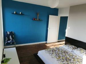 ein blaues Schlafzimmer mit einem Bett und einer blauen Wand in der Unterkunft Charmant T2 refait à neuf, au cœur de Puylaurens in Puylaurens