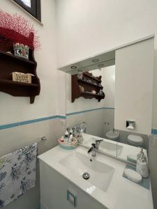 a bathroom with a white sink and a mirror at Villa ValePina in Villasimius