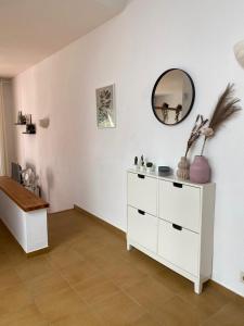 Cette chambre comprend une commode blanche et un miroir. dans l'établissement Coves Noves Nice apartment of 75 m2 10 minutes walk from the beach of Arenal d'en Castell, à Es Mercadal