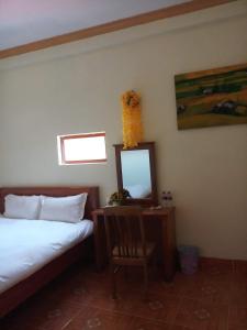 1 dormitorio con cama, espejo y silla en You hour homestay en Sa Pa