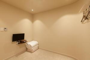 a living room with a tv and a white stool at Jeonju Hanok Little Prince in Jeonju