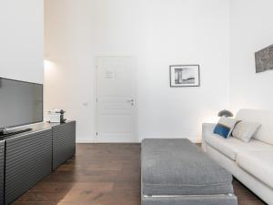 a living room with a couch and a tv at PLEY Cagliari Boutique Suites in Cagliari