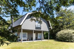 a gray house with a window and a yard at Modo Villa - Granero in Villa La Angostura