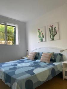 Schlafzimmer mit einem Bett mit einer blauen und weißen Bettdecke in der Unterkunft Coves Noves Nice apartment of 75 m2 10 minutes walk from the beach of Arenal d'en Castell in Es Mercadal