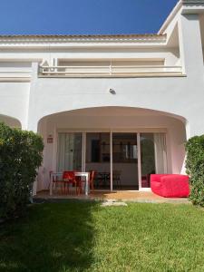 una casa bianca con patio arredato con tavolo e sedie di Coves Noves Nice apartment of 75 m2 10 minutes walk from the beach of Arenal d'en Castell a Es Mercadal