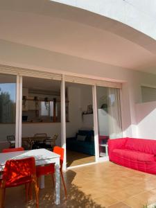 a living room with a red couch and a table at Coves Noves Nice apartment of 75 m2 10 minutes walk from the beach of Arenal d'en Castell in Es Mercadal
