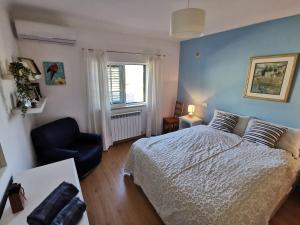 a bedroom with a bed and a chair and a window at Casa Colina Troviscainho in Sertã