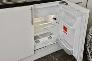 um frigorífico branco vazio com a porta aberta em The White House Retreat em Londres