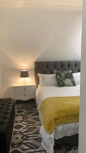 una camera da letto con un letto con una coperta gialla sopra di CALDESMO - Upmarket Apartment a Pretoria