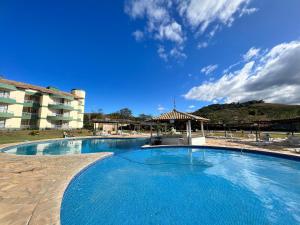 a large swimming pool in front of a building at Flat no Aldeia das Águas Park Resort in Barra do Piraí