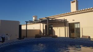 a swimming pool in front of a house at Casa Parreira Raposeira, Algarve in Raposeira