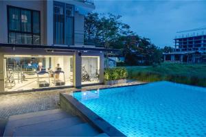 a swimming pool in front of a house at Brique Suite in Chiang Mai