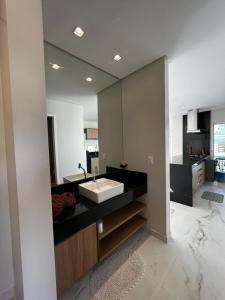 a bathroom with a sink and a large mirror at Casa Maragogi, Piscina, 4 Suítes, 100 Mts Praia in Maragogi
