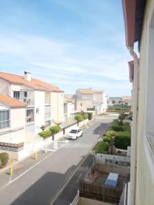 - un balcon donnant sur une rue avec une voiture dans l'établissement Résidence "Les balcons de la mer", à Marseillan