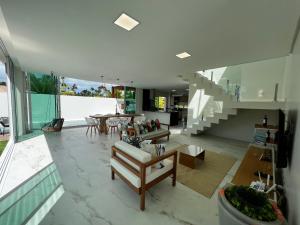 a large living room with a staircase and a table at Casa Maragogi, Piscina, 4 Suítes, 100 Mts Praia in Maragogi