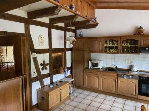 cocina con armarios de madera y horno con fogones en Zur Clemens Hütte en Drolshagen