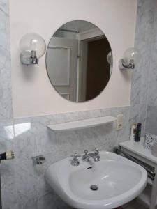 a bathroom with a white sink and a mirror at Urlaub in der königlichen Villa in Berchtesgaden +6 photos