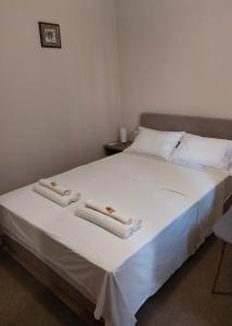a bedroom with a bed with two towels on it at Villa Wind Apartments in Drače
