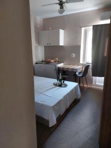 Cette chambre comprend un lit, une table et une cuisine. dans l'établissement Villa Wind Apartments, à Drače