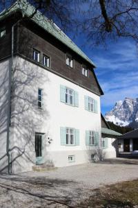 a large white building with green shutters at Lermooser in Lermoos