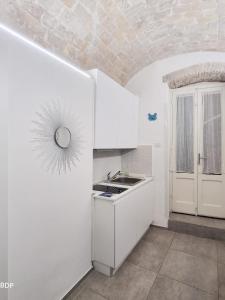 une cuisine blanche avec un évier et une fenêtre dans l'établissement La casa di Michele, à Termoli