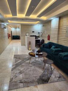 ein Wohnzimmer mit einem Sofa und einem Tisch in der Unterkunft أحلى الليالي للشقق الفندقية in Yanbu