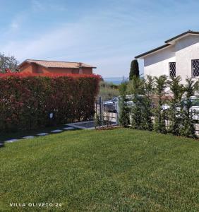 einen Hof mit einem Zaun vor einem Haus in der Unterkunft Villa Oliveto 24 in Bardolino