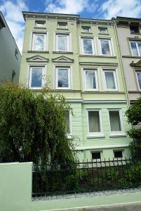 un gran edificio verde y blanco con ventanas en Jessop Haus, en Lübeck