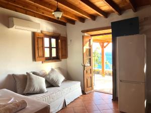 a living room with a couch and a refrigerator at Litois Houses Patmos in Sapsila