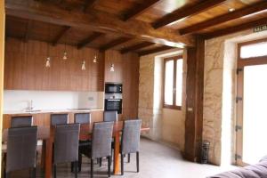 a kitchen with a table and chairs and a counter at Camino de Rosa's in Muros