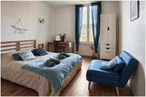una camera con letto e sedia blu di 1001 Ocres ad Apt