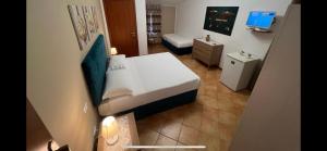 a small room with a bed and a television at La Rosa Blu in San Vito lo Capo
