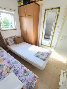 a small room with two beds and a mirror at Charming Cottage Novo Čiče in Novo Čiče