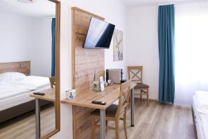 Zimmer mit einem Schreibtisch, einem Bett und einem Spiegel in der Unterkunft Keller Höhe in Andernach