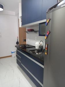 uma cozinha com armários azuis e um lavatório em AP Decorado no Circuito do Carnaval de Salvador em Salvador