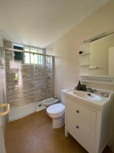 a white bathroom with a toilet and a sink at Coves Noves Nice apartment of 75 m2 10 minutes walk from the beach of Arenal d'en Castell in Es Mercadal