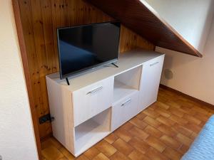a flat screen tv on a white dresser in a room at Casa vacanze Nido al Mare in Sanremo