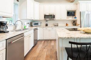 - une cuisine avec des placards blancs et des comptoirs en marbre dans l'établissement 215 Spring Avenue Home, à Anna Maria