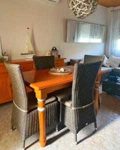 a dining room with a wooden table and chairs at MANDARINA in Riumar