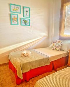 a small bedroom with two beds with towels on them at MANDARINA in Riumar