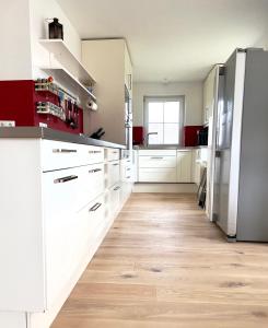 a kitchen with white cabinets and a hardwood floor at Luxus Ferienhaus Erzgebirge in Alleinlage in Kurort Altenberg