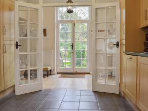 une cuisine avec des portes s'ouvrant sur une salle à manger. dans l'établissement Westgate Cottage, à Saint Lawrence